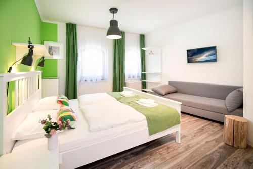 a small bedroom with a bed and a couch at Kostel Panzió in Kesztölc
