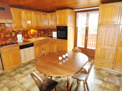 - une cuisine en bois avec une table et des chaises en bois dans l'établissement Apartment La Corne - Apt- 6 by Interhome, à La Chapelle-dʼAbondance