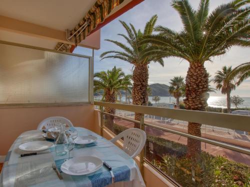 - une salle à manger avec une table et des palmiers dans l'établissement Apartment Dio Brasil-4 by Interhome, à Saint-Cyr-sur-Mer