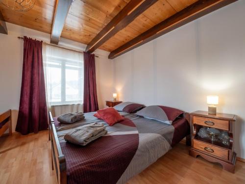 a bedroom with a large bed and a wooden ceiling at Holiday Home Relax & Play by Interhome in Čabar