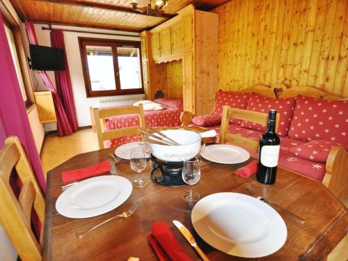 - une table en bois avec des assiettes et une bouteille de vin dans l'établissement Studio Les Cornettes de Bise - Studio Nr 3 by Interhome, à La Chapelle-dʼAbondance
