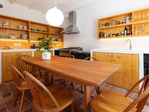 eine Küche mit einem Holztisch und Stühlen in der Unterkunft Holiday Home La Dolce Vita Brezhoneg by Interhome in Trémeven