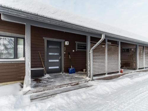 una casa con una puerta azul en la nieve en Holiday Home Kotomänty 2 by Interhome, en Ruka