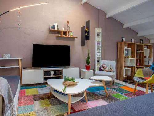 un salon avec une télévision et une table dans l'établissement Holiday Home Rive Droite by Interhome, à La Bernerie-en-Retz