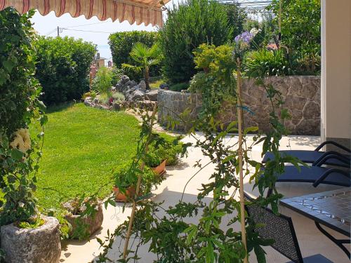 einen Garten mit einem Tisch und einigen Pflanzen in der Unterkunft Apartment JF Rezine by Interhome in Lovran