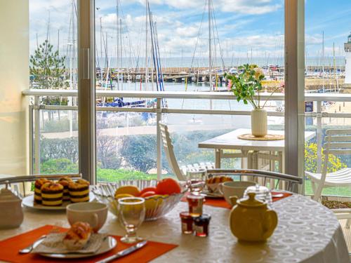 - une table avec de la nourriture et une vue sur le port de plaisance dans l'établissement Studio Résidence Le Mané by Interhome, à Quiberon
