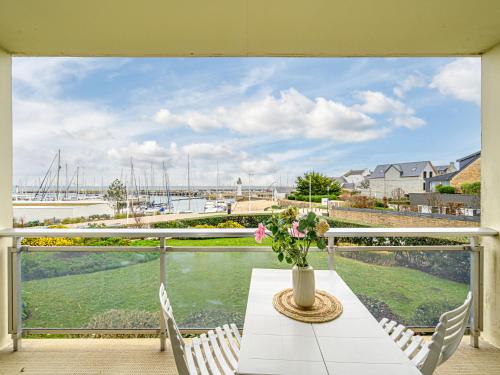 une table avec un vase de fleurs sur un balcon dans l'établissement Studio Résidence Le Mané by Interhome, à Quiberon