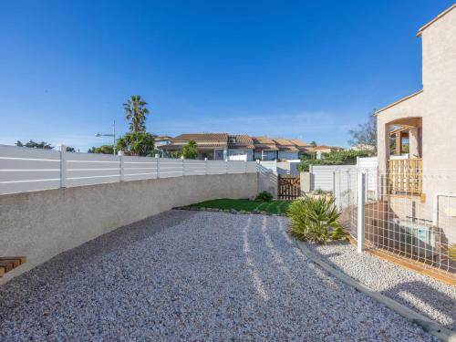 un pont sur une route en gravier à côté d'une maison dans l'établissement Holiday Home Rochelongue by Interhome, au Cap d'Agde