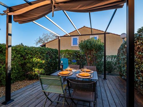 un patio avec une table, des chaises et un parasol dans l'établissement Holiday Home Beau Soleil by Interhome, à Narbonne-Plage