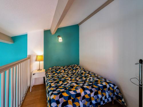 une chambre avec un lit et un mur bleu dans l'établissement Holiday Home Beau Soleil by Interhome, à Narbonne-Plage
