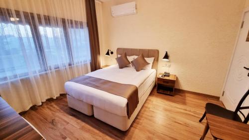 Un dormitorio con una cama y una ventana grande. en La Pearl Konaklama, en Estambul