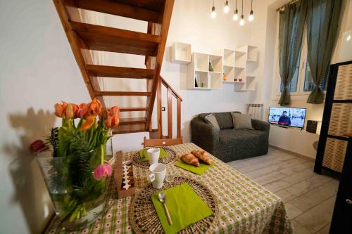 una sala de estar con una mesa con flores y una silla en Lepontina, 13 - Grazioso e confortevole, en Milán