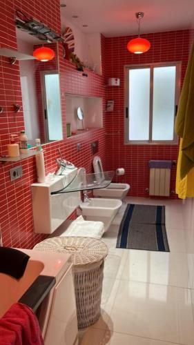 a bathroom with two sinks and a red wall at Apartamento en Panaderos in Valladolid