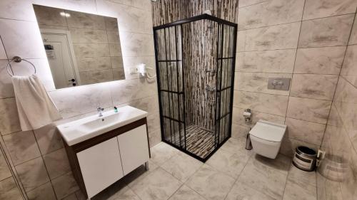 Un baño con ducha, lavabo e inodoro. en La Pearl Konaklama, en Estambul