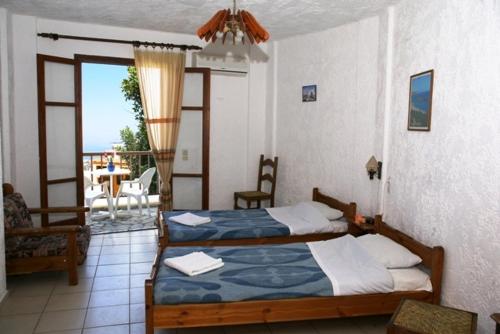 a bedroom with two beds and a balcony at Elgoni Apartments in Hersonissos