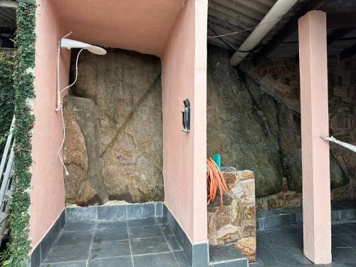 a pink wall with a shower in a room at Refúgio dos gatos in Ubatuba