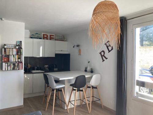 une cuisine avec une table et des chaises dans une pièce dans l'établissement EOLE, Idéalement situé sur le port de St Martin de Re, à Saint-Martin-de-Ré