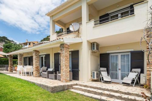 a house with a patio and chairs in the yard at Agapi mou in Glyfada