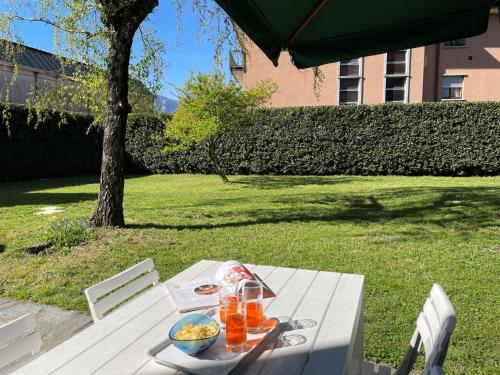 a picnic table with a bowl of food and orange juice at Apartment Betulla-2 by Interhome in Dervio