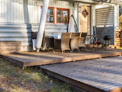 - une terrasse couverte avec des chaises assises au-dessus d'une maison dans l'établissement Holiday Home Kulta-käkönen 17 by bomba by Interhome, à Nurmes