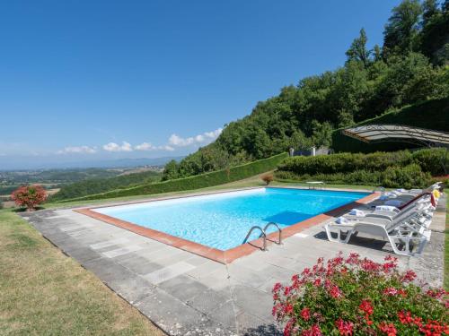 a swimming pool with chairs next to a mountain at Holiday Home La Terrazza by Interhome in Vicchio