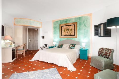 a bedroom with a bed and a desk and a chair at Hotel Stefania Boutique Hotel by the Beach in Olbia
