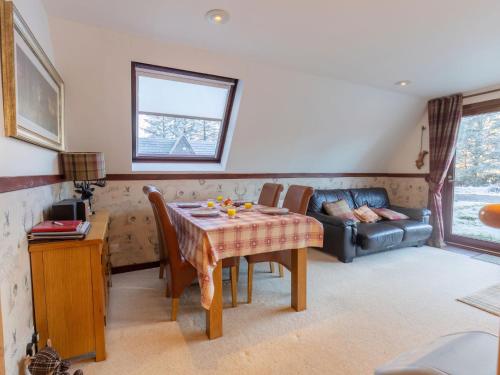 a living room with a table and a couch at Chalet Glen Muir Lodge by Interhome in Spean Bridge