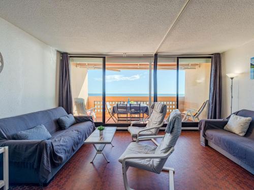 d'un salon avec un canapé et des chaises ainsi que d'un balcon. dans l'établissement Apartment Les Argonautes-6 by Interhome, au Barcarès