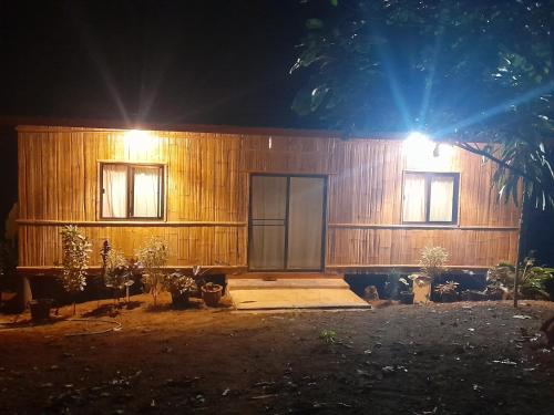 a wooden cabin with a large door at night at Dawdoylisu Chiangmai in Ban Ton Kham