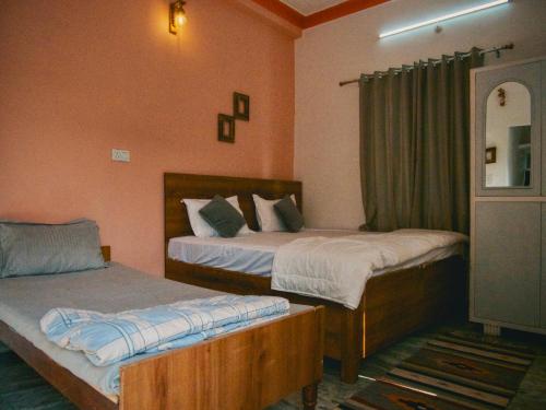 a bedroom with two beds and a window at Flow House in Rishīkesh