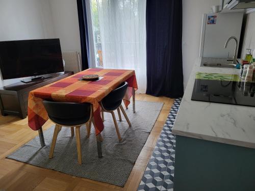 une cuisine avec une table en bois et deux chaises dans l'établissement Paris/La Défense 10' en train 2 CHB, à Colombes