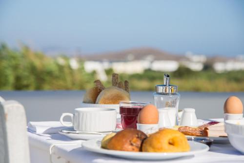 a table with plates of food and eggs on it at Cycladic Islands Hotel & Spa in Agia Anna Naxos