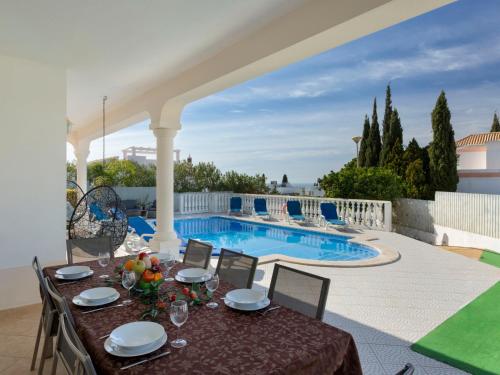 une terrasse avec une table et des chaises ainsi qu'une piscine dans l'établissement Villa Jardin d'Eden by Interhome, à Albufeira