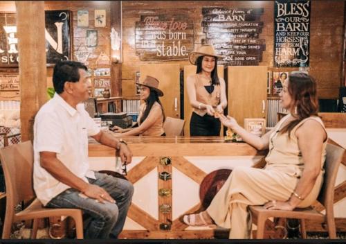 un grupo de personas sentadas alrededor de una mesa en un restaurante en Barn Hostel en Panglao