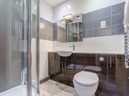 a bathroom with a toilet and a sink and a shower at 2 Bed in Ullswater 80556 in Watermillock