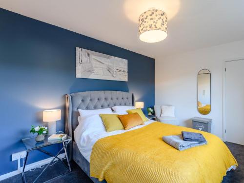 een slaapkamer met een groot bed en een gele deken bij 2 Bed in Lulworth Cove 79228 in West Lulworth