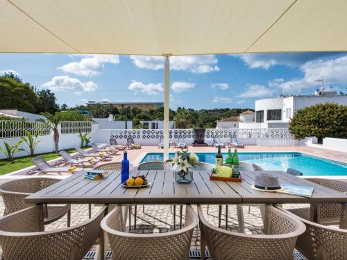 een patio met een tafel en stoelen en een zwembad bij Villa Aladdin by Interhome in Albufeira