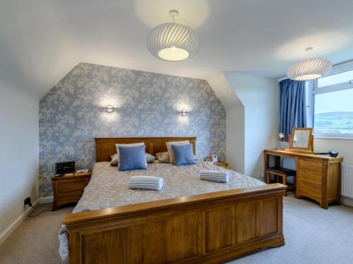 a bedroom with a large bed with blue walls at 3 Bed in Swanage 79405 in Swanage