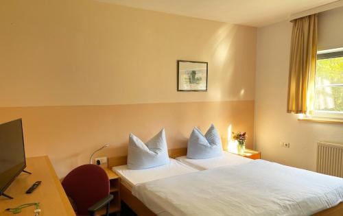 ein Hotelzimmer mit einem Bett mit weißen Kissen in der Unterkunft A&S Ferienzentrum Schwerin in Schwerin