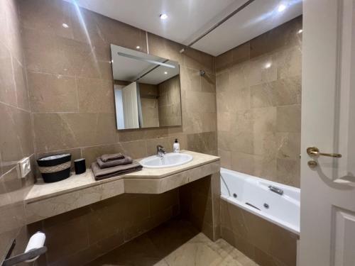 ein Badezimmer mit einem Waschbecken, einer Badewanne und einem Spiegel in der Unterkunft Apartamento en Coto Real 412 in Manilva