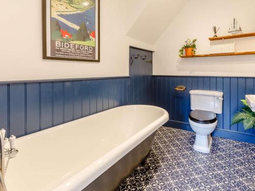 a bathroom with a tub and a toilet at 3 Bed in Bideford 79552 in Bideford