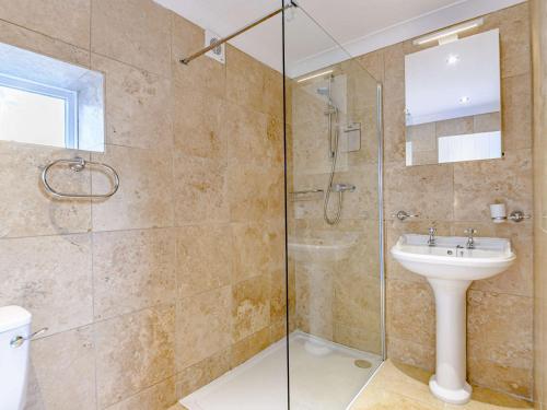 a bathroom with a glass shower and a sink at 2 Bed in Alnmouth 81280 in Alnmouth