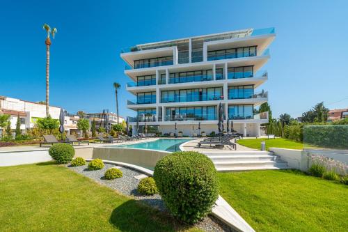 een groot wit gebouw met een zwembad in een tuin bij The Palmiers in Paphos City