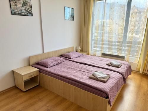 sypialnia z łóżkiem z fioletową pościelą i oknem w obiekcie Aspen Golf - private apartments w mieście Razłog