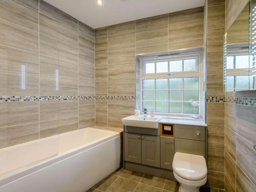 uma casa de banho com uma banheira, um WC e um lavatório. em 3 Bed in Corfe Castle 81369 em Corfe Castle