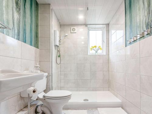 Baño blanco con aseo y lavamanos en 2 Bed in St Andrews 81388, en Errol