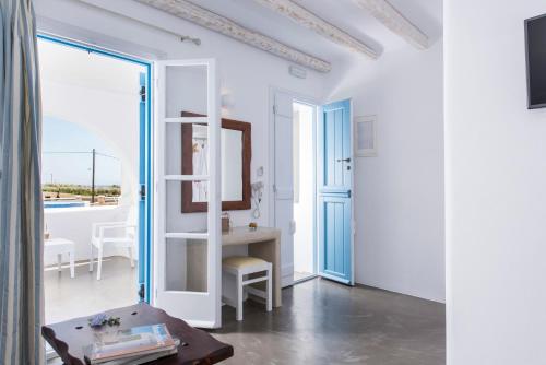 a white room with a table and a mirror at Cycladic Islands Hotel & Spa in Agia Anna Naxos