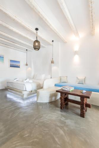a white living room with a couch and a table at Cycladic Islands Hotel & Spa in Agia Anna Naxos