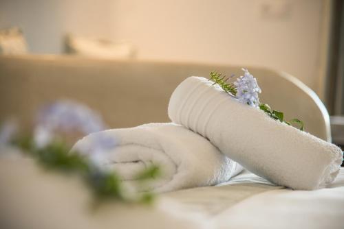 a rolled up towel with flowers on top at Cycladic Islands Hotel & Spa in Agia Anna Naxos