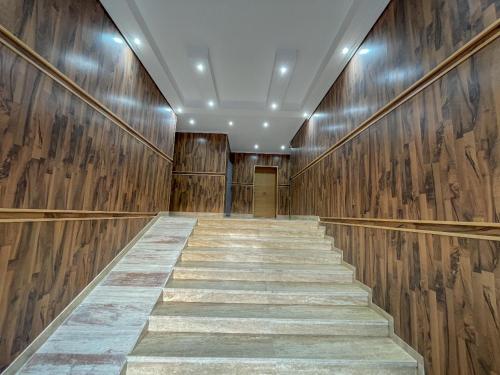 a hallway with wooden walls and a staircase at Appartement las palmas family only in Tangier